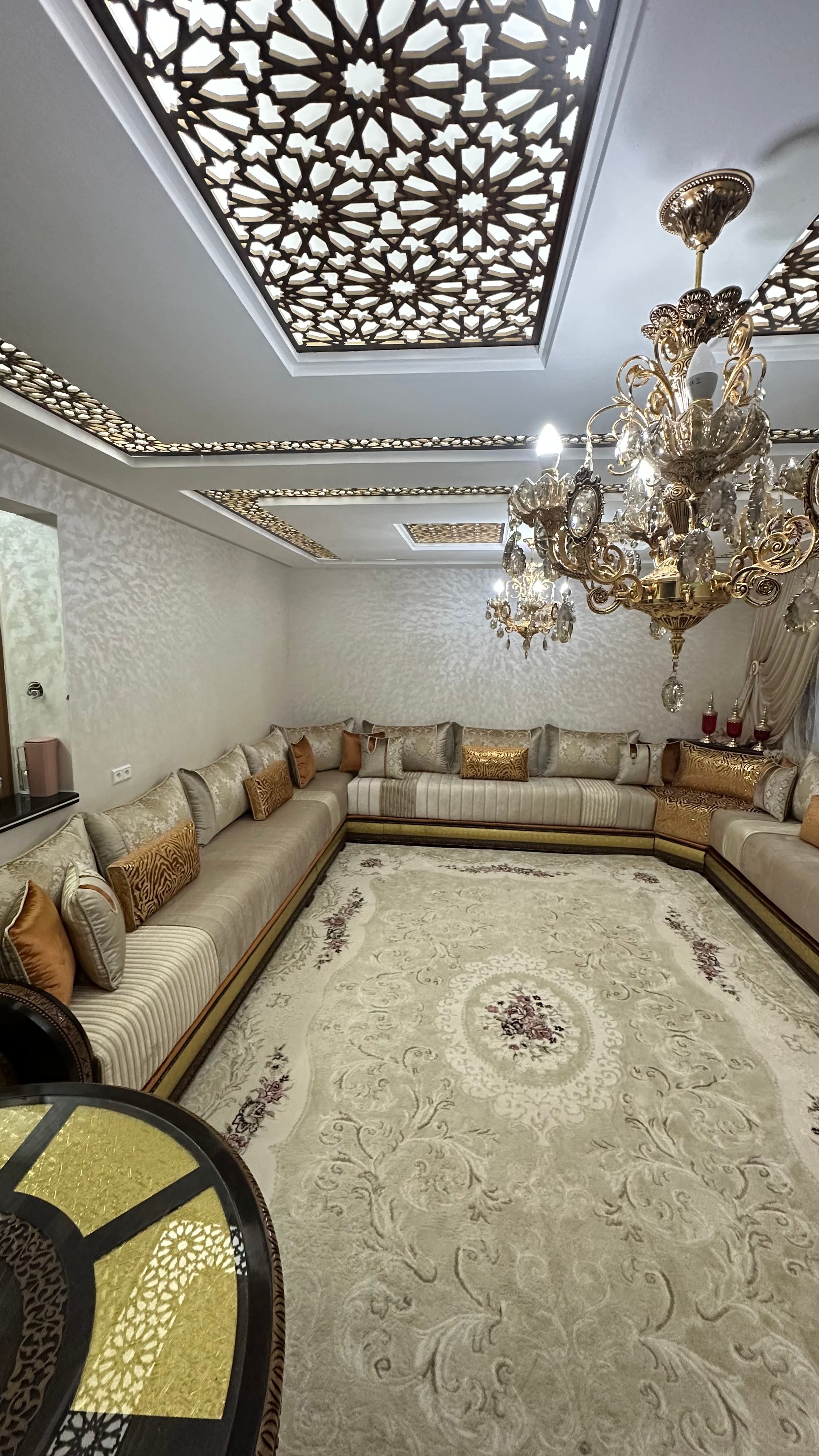 Salon avec plafond en bois sculpté et lustre en cristal